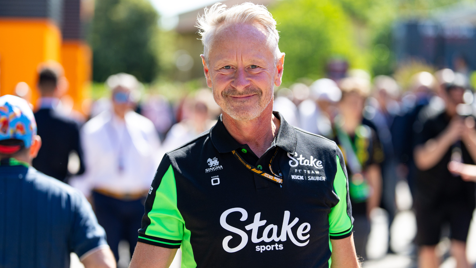 Jonathan Wheatley wearing a black and neon green Stake F1 Team Kick Sauber polo shirt in the paddock.