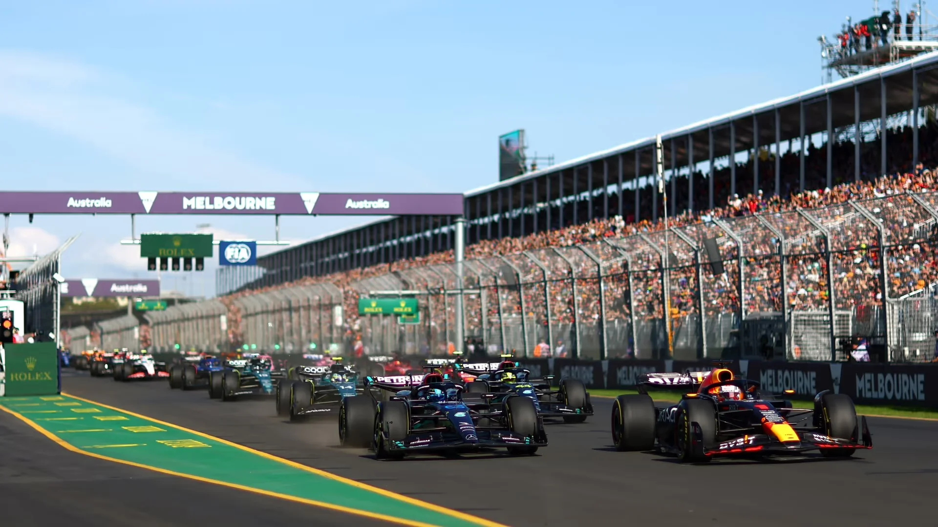 Australian Grand Prix at Albert Park in Melbourne with Formula 1 cars racing past packed grandstands and Winners List 1985–2026 title overlay