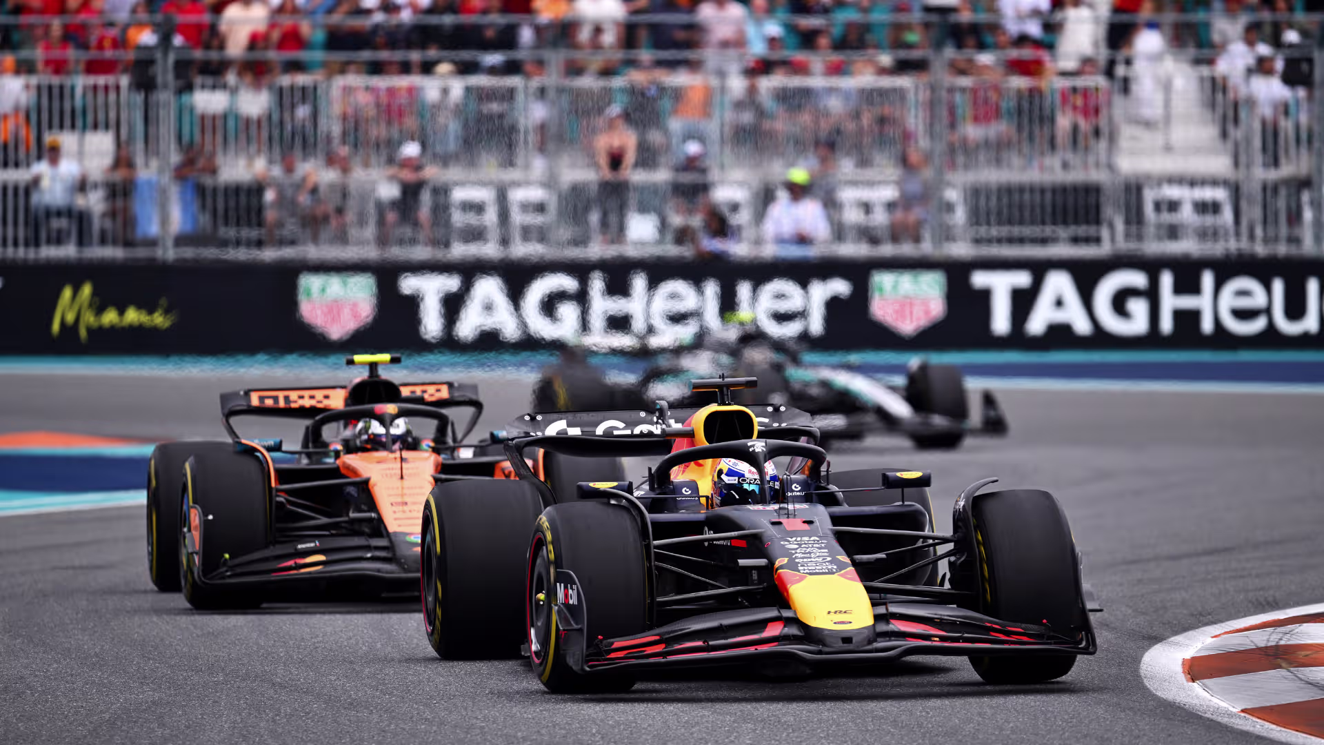 A Red Bull Formula 1 car leading a McLaren closely through a corner at the Miami Grand Prix, highlighting the tight grid for 2026 F1 betting odds.