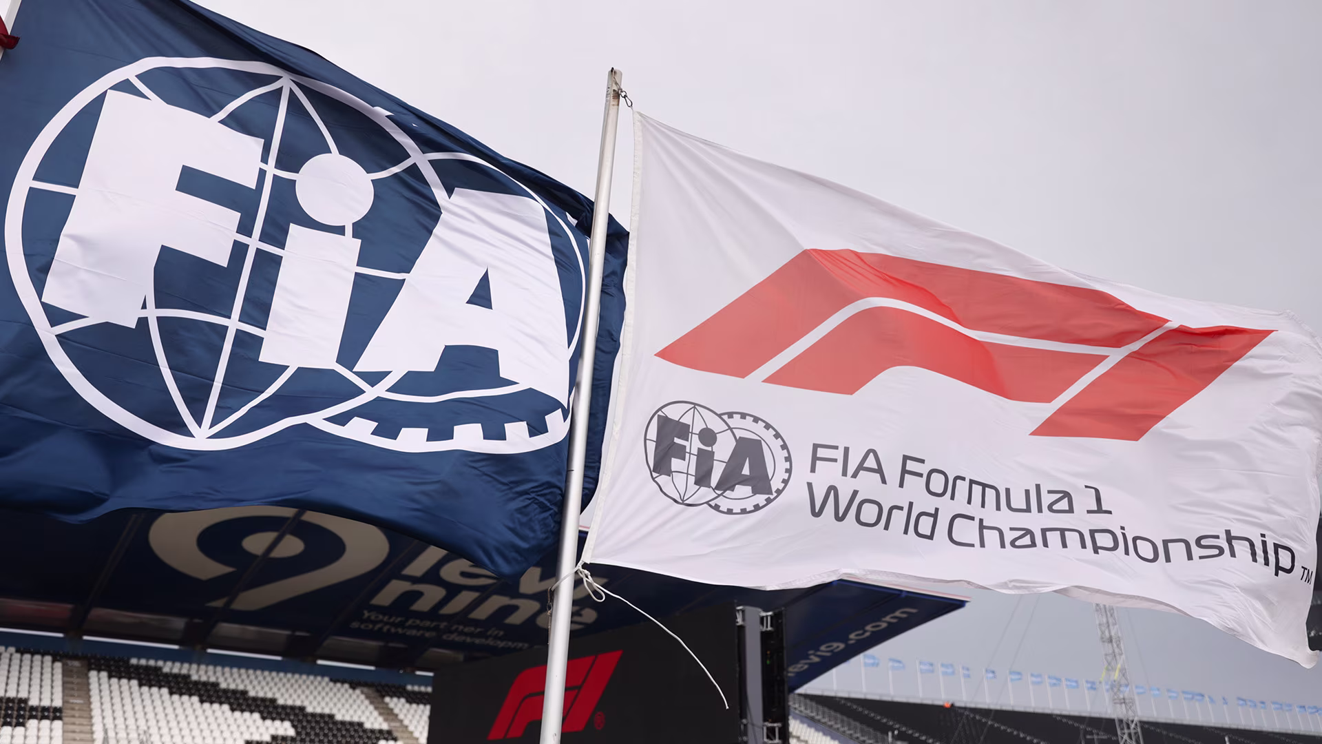 FIA and Formula 1 flags waving side-by-side, representing the governing bodies behind the 2026 F1 rule changes.